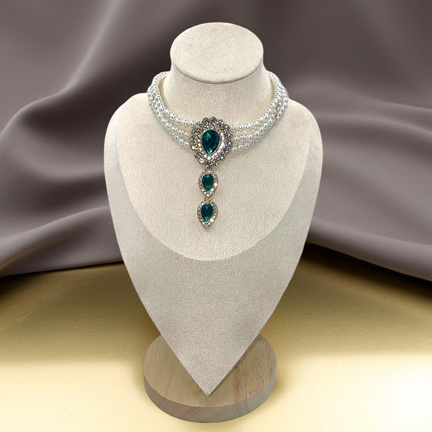 Emerald Pearl Jewelry Set – Three-strand pearl necklace and hand chain bracelet featuring emerald and rhinestone accents.
